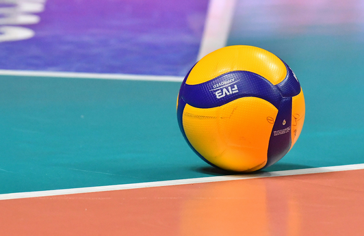 Ein Volleyball liegt auf einem Spielfeld am Boden