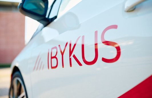 Abbildung der IBYKUS Word-Bild-Marke auf einem Dienstwagen.