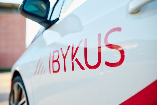Ein Auto seitlich fotografiert mit dem IBYKUS Logo foliert