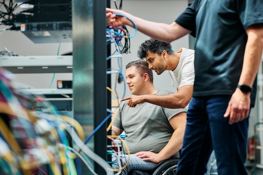 Mitarbeitende arbeiten an einem Serverturm