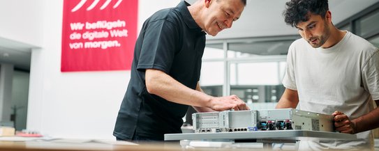 Zwei Männer schauen gemeinsam in einen geöffneten Computer