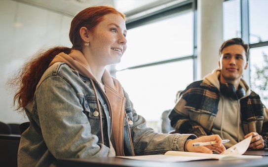 Jugendliche sitzen gemeinsam in einem Klassenraum und schauen in Richtung Tafel